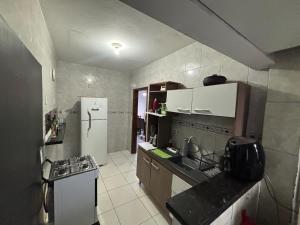 cocina pequeña con nevera y fogones en Apartment 2 minutes from the beach, en Itajaí