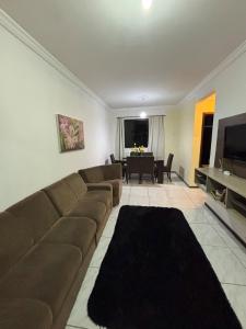 Una sala de estar con un sofá y un comedor. en Apartment 2 minutes from the beach, en Itajaí