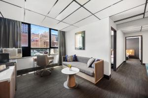 Cosmo on Bank في أديلايد: غرفة معيشة مع أريكة وطاولة