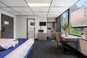 Cosmo on Bank في أديلايد: غرفة نوم بها سرير ومكتب ونافذة