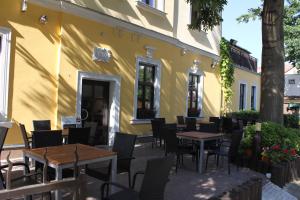 un restaurant avec des tables et des chaises en face d'un bâtiment dans l'établissement Hotel Zlatý Kříž, à Teplice