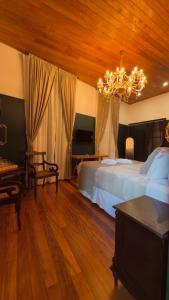 a bedroom with a large bed and a chandelier at Pousada Elite in Santa Teresa