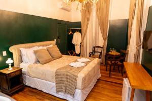 a bedroom with a bed with a green wall at Pousada Elite in Santa Teresa