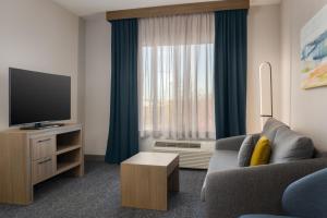 a living room with a couch and a television at Homewood Suites by Hilton Toronto-Ajax in Ajax