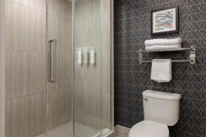 a bathroom with a shower and a toilet and towels at Homewood Suites by Hilton Toronto-Ajax in Ajax +12 photos