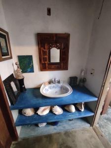 un bagno con un lavandino e una mensola blu con le scarpe di Casa Anéis de Saturno a Pipa