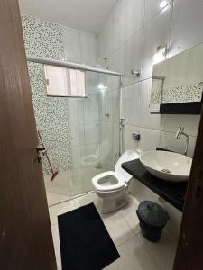 a bathroom with a toilet and a sink at Casa da paz in Palmas +9 photos