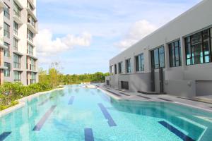 a large swimming pool next to a building at Connext Residence Phuket in Phuket
