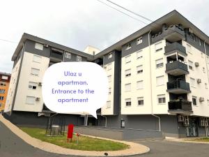 a building with a sign that reads uber u experiment entrance to the apartment at Apartman Max in Modriča