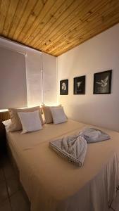 a bedroom with a large bed with two pillows at Pousada Sol e Mar in Farol de Santa Marta