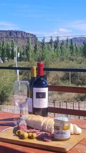 una mesa con una botella de vino y una copa en Preciosa Casa con Terraza al Valle Grande, San Rafael Mendoza de 1 a 5 Personas, en Valle Grande