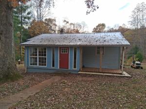 una piccola casa blu con una porta rossa di The Blue Cabin a Stuart