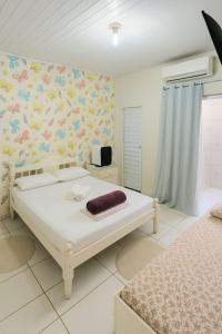 a bedroom with a bed and a wall with flowers at ꕥ Suíte Deluxe Privativa ꕥ Cantinho da Margarida ꕥ Hospedagem & Hostel Premium in Belém