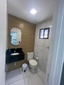 a bathroom with a toilet and a sink and a mirror at Apto aconchegante na Boa Vista - 2 Quartos - Perto Consulado in Recife