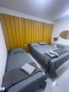 a bedroom with two beds and a yellow wall at Apto aconchegante na Boa Vista - 2 Quartos - Perto Consulado in Recife