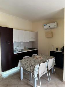 a kitchen with a table with chairs and a sink at Tropical Paradise in Santa Maria