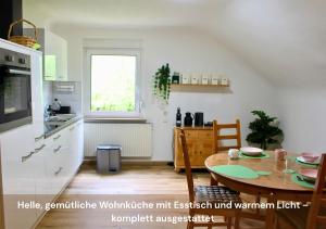 Ferienwohnungen Schwarzhof في نوهفيلدين: مطبخ مع طاولة وغرفة طعام