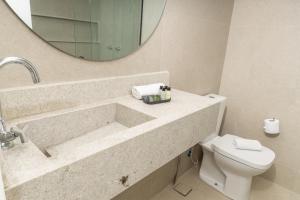 a bathroom with a sink and a toilet and a mirror at Sereno Hotel in Cabo Frio +17 photos