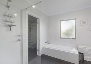 a white bathroom with a tub and a shower at The Summer Residence Middleton in Middleton +21 photos