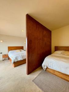 1 dormitorio con 2 camas y una gran pared de madera en Cabañas Las Camelias, en Cuetzalán del Progreso 15 fotos más