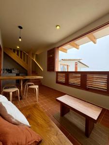 sala de estar con ventana grande y mesa en Cabañas Las Camelias, en Cuetzalán del Progreso