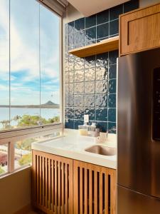 a kitchen with a sink and a large window at Ap Da Ilha in Alter do Chao