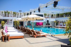 a pool with chairs and umbrellas in front of a hotel at Sun City Hotel - The Gabriel in Cairo