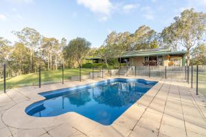 an image of a swimming pool in front of a house at Mara Luxe Farm Stay 20 mins from Beach in Forster