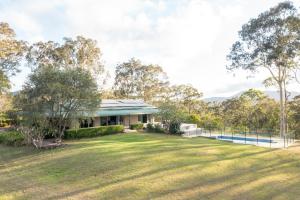 a house with a large lawn in front of it at Mara Luxe Farm Stay 20 mins from Beach in Forster