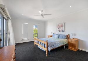 a bedroom with a bed and a ceiling fan at The Summer Residence Middleton in Middleton
