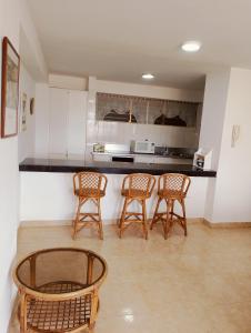 a kitchen with four chairs and a counter top at Apartamento Isla de Margarita in Pampatar