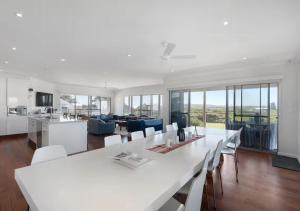 a kitchen and living room with a white table and chairs at The Summer Residence Middleton in Middleton
