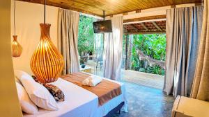 Ένα ή περισσότερα κρεβάτια σε δωμάτιο στο Aruana Suites com Cafe da manha,Piscina, Reserva Natural da Sapiranga 5km da Vila de Praia do Forte