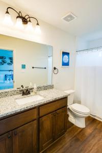 ein Badezimmer mit Waschbecken, Toilette und Spiegel in der Unterkunft New Modern Urban Home Near Top Attractions in Helotes