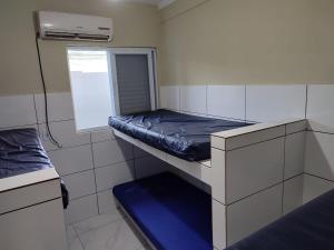 Una pequeña habitación con una litera y una ventana. en Casa para temporada 2 Roberto, en Praia Grande