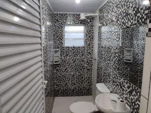 un baño con inodoro y lavabo en Casa para temporada 2 Roberto, en Praia Grande 20 fotos más