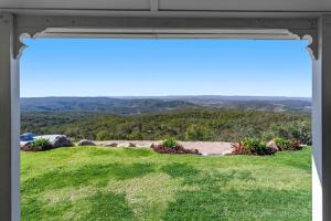 a window view of a field of grass with mountains in the background at The Quince Cottage - 2 Bedrooms in Ravensbourne