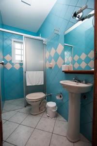 Un baño azul con inodoro y lavabo. en Ilha Náutica, en Florianópolis