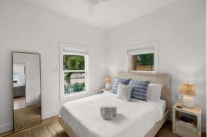um quarto branco com uma cama grande e um espelho em NEW Casa Padron & La Casita em Tampa