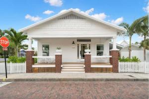Uma casa branca com um sinal de stop à frente. em NEW Casa Padron & La Casita em Tampa