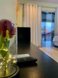 a flower in a glass vase next to a remote control at Lar dos Lençóis in Barreirinhas
