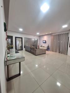 uma grande sala de estar com um sofá e uma mesa em Casa de 3 quartos com Piscina 2km da Praia Araçagy em São Luís