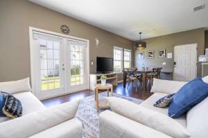 a living room with white couches and a dining room at Villa Hakuna Matata- Lucaya Village Resort in Kissimmee