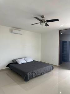 a bedroom with a bed with a ceiling fan at Private Canarian house with pool in Conkal