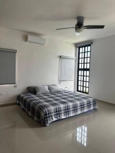 a bed in a white room with a window at Private Canarian house with pool in Conkal +52 photos