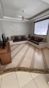 een woonkamer met twee banken en een groot raam bij Toque Toque Grande Paraiso in Sao Paulo