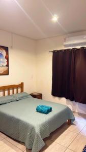 a bedroom with a bed and a black curtain at Pousada ENCANTOS DO MAR in Ubatuba