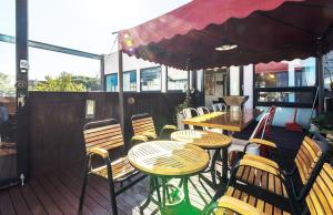 a patio with tables and chairs and an umbrella at Paju Gallery Café Pension Soon in Paju