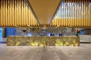 a lobby with two people sitting at a reception desk at Meriton Suites World Tower, Sydney in Sydney +58 photos