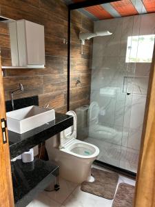 a bathroom with a toilet and a shower and a sink at Chalé do Campo in Sumidouro +50 photos